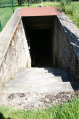 Entrée d'un blockhaus en parfait état dans un jardin privé.